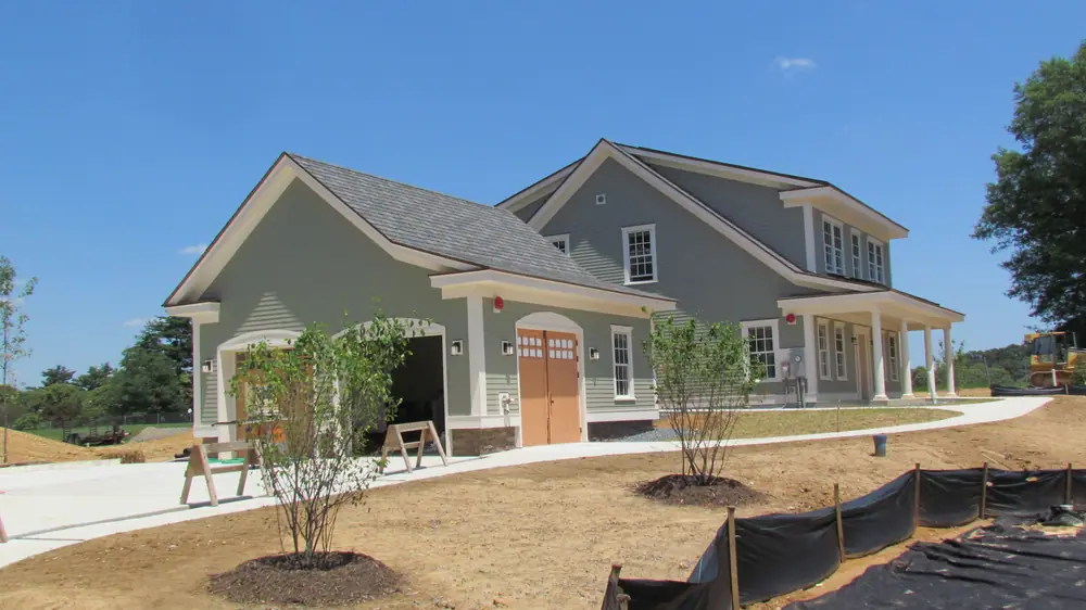 New residential home with a covered porch, garage and young landscaping