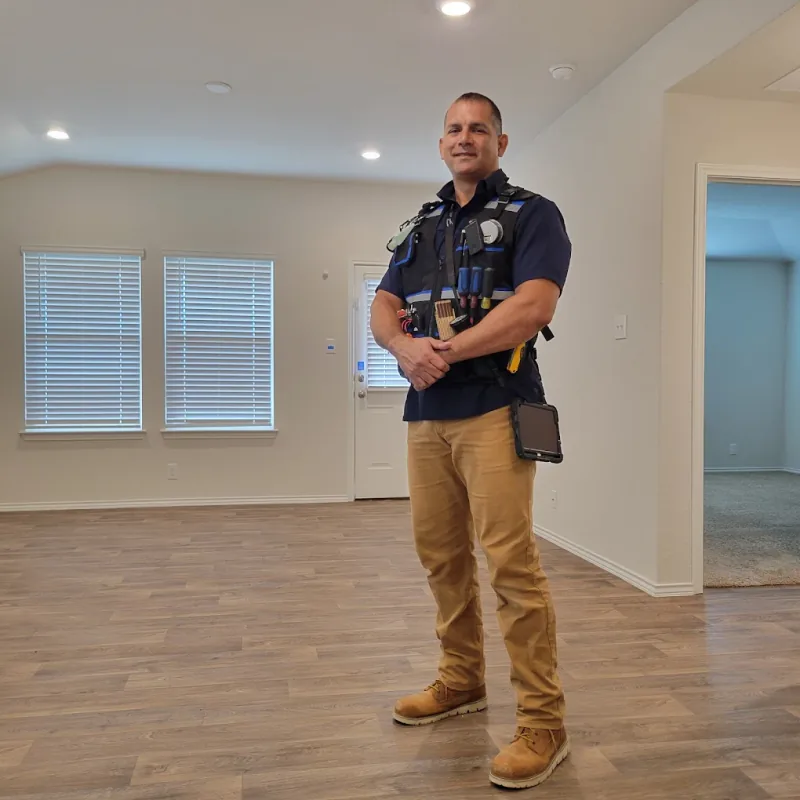 Jeremy Luera in his inspection vest, with his tools and tablet, in an empty home
